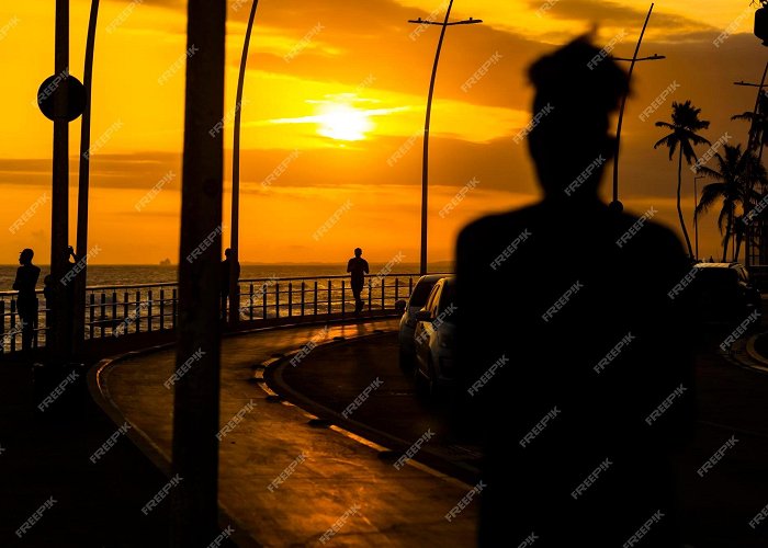 Ondina Beach Premium Photo | Silhouette of people walking against dramatic ... photo